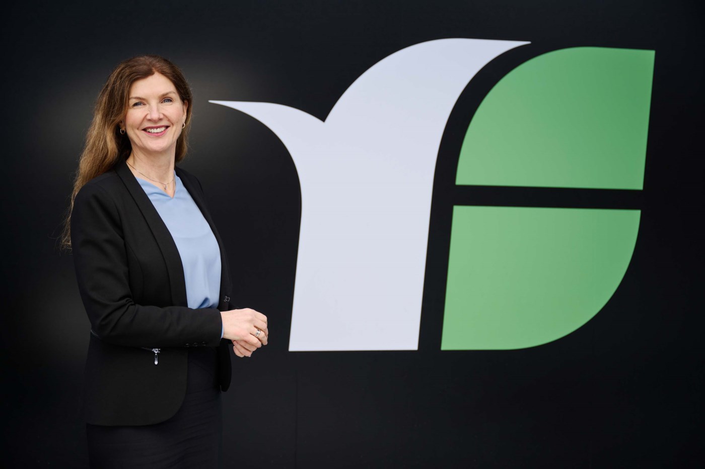 Adm. banksjef Siri Berggreen står utenfor logoen til Romerike Sparebank