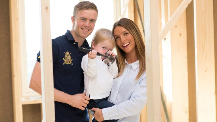 Smilende familie i nybygg. foto